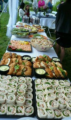 a table with many trays of food on it