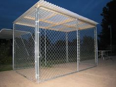 a large chain link fence next to a small white table and chair in the background