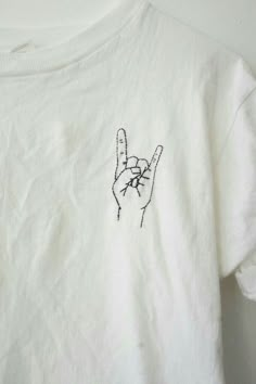 a white t - shirt with a hand drawn on it