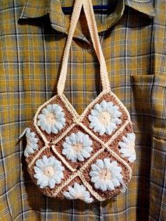 a crocheted bag hanging from a man's shirt with flowers on it