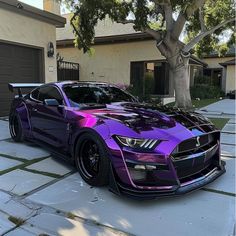 a purple and black car parked in front of a house