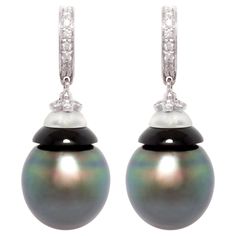 The black Tahitian pearl earrings feature 2 lovely Tahitian pearls of 14mm diameter with high luster and beautiful nacre. The pearls originate in French Polynesia and were subjected to no chemical treatment to enhance their natural beauty. The pearls are suspended from 2 hoops set with 0.30 carats of diamonds of top quality (color, clarity and cut, F-G/VVS). The design is complete with black onyx and frosted crystal. The earrings were entirely hand made in our own workshop in Italy according to an original design by Ella Gafter. The item is signed EG. Pearl Diamond Earrings, Art Deco Drop Earrings, Modern Hoop Earrings, Tahitian Pearl Earrings, Diamond Tops, Tahitian Black Pearls, Pearl And Diamond Earrings, White Gold Earrings, Tahitian Pearls