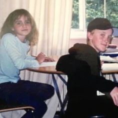 an old photo of two people sitting at a table