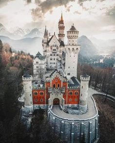 an aerial view of a castle with mountains in the background