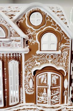 a close up of a gingerbread house with white trim