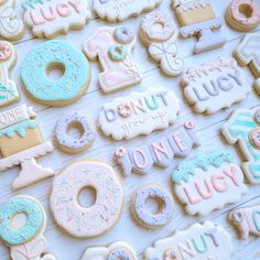 some decorated cookies that are on a white table with the words donut, donuts and one last