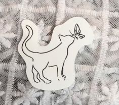 a cat with a bow on it's head sitting on a lace tablecloth