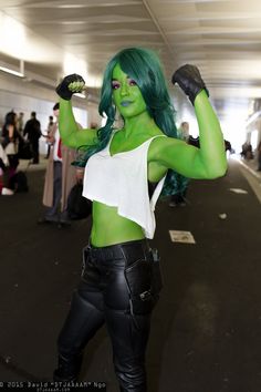 a woman with green hair and black leather pants