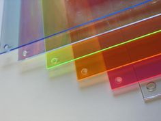 three pieces of colored glass sitting on top of a white table next to each other