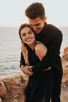 a man and woman embracing each other by the water