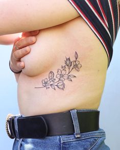 a woman's stomach with a flower tattoo on her belly and the bottom part of her stomach