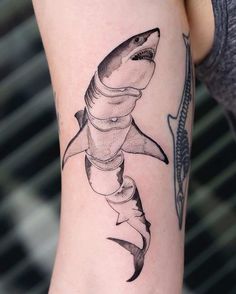 a woman's arm with a shark tattoo on it