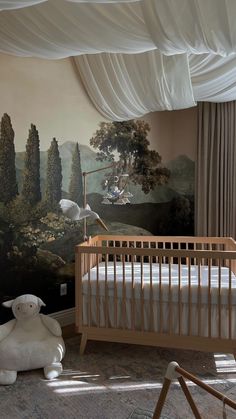 a baby's room with a large painting on the wall and a teddy bear