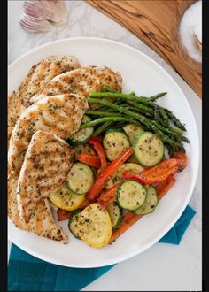 a white plate topped with chicken and veggies