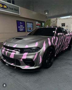 a silver car with pink zebra print on it