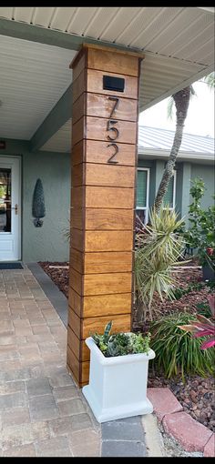 the front entrance to a house with a planter on the sidewalk