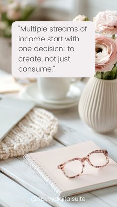 a white table topped with pink flowers and glasses next to a notepad that says multiple streams of income start with one decision to create not just consume