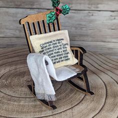 a wooden rocking chair with a white blanket and a christmas ornament on it