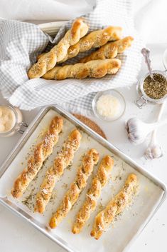 breadsticks on a baking sheet with salt and pepper sprinkles next to them