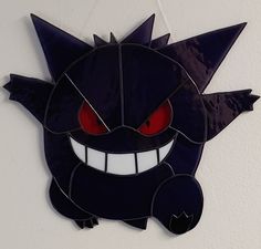 a close up of a paper cut out of a cartoon character with red eyes and fangs