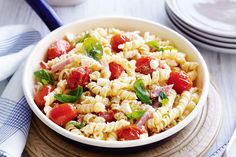 a white bowl filled with pasta and tomatoes