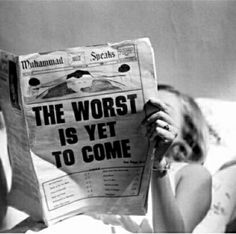 a woman laying in bed reading a newspaper with the words, the worst is yet to come