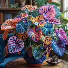 a potted plant with multicolored leaves sits on a table