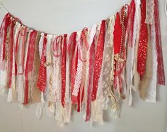 there is a red and white garland hanging from the wall with laces on it