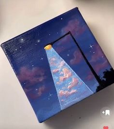 a small box with an image of a sky and stars on it, sitting on top of a table