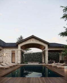 an outdoor swimming pool with lounge chairs and a pergolated area in the background