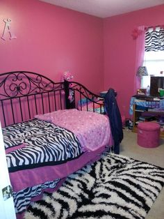 a bedroom with pink walls and zebra print bedding