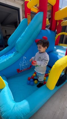 a little boy playing in an inflatable bounce house