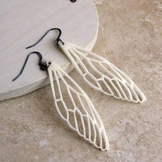 two pairs of white earrings sitting on top of a table