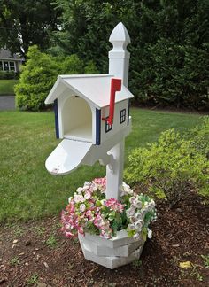 a white mail box with flowers in it