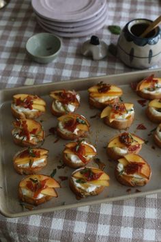 small appetizers are arranged on a baking tray with utensils in the background