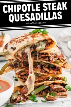 a stack of quesadillas stacked on top of each other next to a bowl of salsa