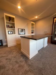 an empty living room with white cabinets and carpeted flooring is pictured in this image