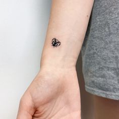 a small butterfly tattoo on the wrist