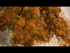 a white plate topped with rice and meat covered in gravy