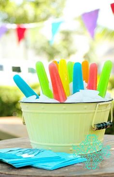 a bucket filled with ice cream and colorful popsicles