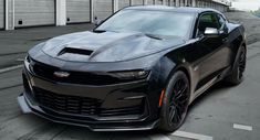 a black chevrolet camaro is parked on the street