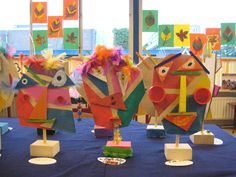 colorful paper puppets are on display in front of a window