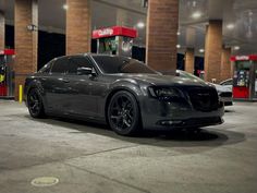 a black car parked in front of a gas station