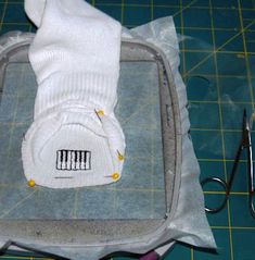 a pair of white socks sitting on top of a cutting board next to some scissors