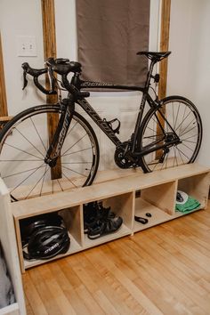 there is a bike that is sitting on a shelf in the room next to some shoes