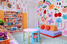 a child's playroom with colorful wallpaper and furniture