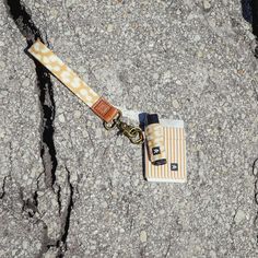 a lanyard with an orange and white pattern on it sitting in the middle of some rocks