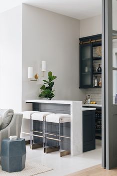 a living room filled with furniture and a bar