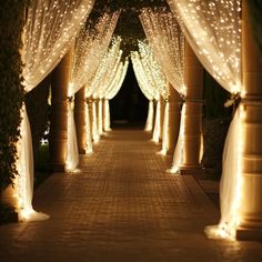 an outdoor walkway decorated with lights and drapes