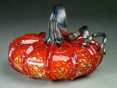 an orange glass pumpkin sitting on top of a table